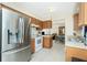 An open kitchen design featuring a stainless steel refrigerator, wood cabinets, and tile flooring at 12185 Weimar Ave, Port Charlotte, FL 33981