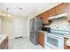 A functional kitchen with stainless steel appliances, wooden cabinets, and convenient access to an exterior door at 12185 Weimar Ave, Port Charlotte, FL 33981