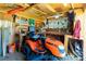 Organized shed interior with ample storage and an orange riding lawn mower at 12185 Weimar Ave, Port Charlotte, FL 33981