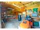 Well-lit shed interior featuring storage shelves, tools, and an orange riding lawn mower at 12185 Weimar Ave, Port Charlotte, FL 33981