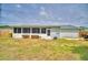 Backyard view with a sunroom, mature landscaping, and a wood fence at 13495 Newport Ave, Port Charlotte, FL 33981