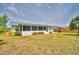 Spacious backyard featuring an enclosed sunroom, wooden benches, and mature landscaping at 13495 Newport Ave, Port Charlotte, FL 33981