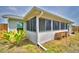Home's screened patio and adjacent garden boxes offer outdoor living with a verdant view at 13495 Newport Ave, Port Charlotte, FL 33981