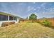 Large, fenced backyard with a palm tree, screened patio, and space for gardening at 13495 Newport Ave, Port Charlotte, FL 33981