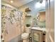 Bright bathroom featuring modern light fixtures, floating shelves, and a shower with decorative floral curtain at 13495 Newport Ave, Port Charlotte, FL 33981