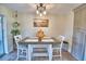This dining room features an industrial modern light fixture and a farmhouse-style table set for four at 13495 Newport Ave, Port Charlotte, FL 33981