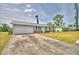 Charming one-story home with a metal roof, an attached garage and a long driveway at 13495 Newport Ave, Port Charlotte, FL 33981