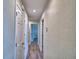 Hallway with modern gray wood-look flooring leads to other rooms in the house at 13495 Newport Ave, Port Charlotte, FL 33981