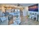 Open-concept living room and kitchen with wood floors, neutral colors, and a large television at 13495 Newport Ave, Port Charlotte, FL 33981