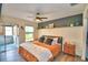 Bright and spacious main bedroom boasts wood-look floors, fan, sliding glass door and a decorative shelf at 13495 Newport Ave, Port Charlotte, FL 33981