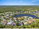 Aerial view of homes surrounding a pond and golf course within a lush, green community at 13783 Palmetto Point Ct, Port Charlotte, FL 33953