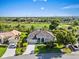Charming single-story home featuring a well-manicured lawn, decorative shrubs, and a tranquil golf course backdrop at 13783 Palmetto Point Ct, Port Charlotte, FL 33953