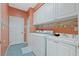Functional laundry room equipped with washer, dryer, sink, and ample storage cabinets at 13783 Palmetto Point Ct, Port Charlotte, FL 33953