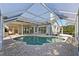 Inviting screened-in pool surrounded by a brick patio, with views of the home's architecture at 13783 Palmetto Point Ct, Port Charlotte, FL 33953