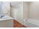 View of the bathroom with tub, vanity, and walk-in shower with glass block wall at 143 Tropicana Dr # 1012, Punta Gorda, FL 33950