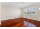 Bedroom featuring hardwood floors, crown molding, ceiling fan, and large window with blinds at 143 Tropicana Dr # 1012, Punta Gorda, FL 33950