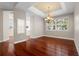 Dining room featuring hardwood floors, elegant chandelier, and view into the kitchen at 143 Tropicana Dr # 1012, Punta Gorda, FL 33950