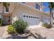 The property's exterior boasts a paved driveway, lush landscaping and a two-car garage in neutral color palette at 143 Tropicana Dr # 1012, Punta Gorda, FL 33950