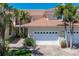 Exterior shot of the home's garage, featuring a brick paved drive, tropical landscaping, and neutral color palette at 143 Tropicana Dr # 1012, Punta Gorda, FL 33950