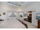 Primary bedroom with tray ceiling, fan, neutral walls and ensuite bath at 1435 Pine Island Ct, Punta Gorda, FL 33950