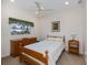 This bright bedroom has a ceiling fan and window with a view of the lovely home exterior at 1435 Pine Island Ct, Punta Gorda, FL 33950