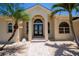 Stunning home featuring a beautiful front entrance with double doors, arched windows, and tropical landscaping at 1435 Pine Island Ct, Punta Gorda, FL 33950