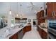 Kitchen with white tile floor, wooden cabinets, granite counters, and stainless steel appliances at 1435 Pine Island Ct, Punta Gorda, FL 33950