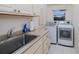 Well-lit laundry room complete with washer, dryer, sink, and plenty of storage space at 1435 Pine Island Ct, Punta Gorda, FL 33950