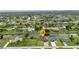 An aerial view shows the home, with a well manicured lawn and waterfront views at 15 Tournament Rd, Rotonda West, FL 33947