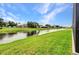 A green lawn and a small body of water are visible in this backyard at 15 Tournament Rd, Rotonda West, FL 33947
