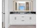 A modern bathroom featuring a double vanity with an illuminated mirror at 15 Tournament Rd, Rotonda West, FL 33947