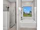 A modern bathroom with soaking tub, glass shower, and beautiful tile work and a window with lush views at 15 Tournament Rd, Rotonda West, FL 33947