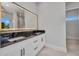 Bright bathroom with white cabinets, a large, illuminated mirror, and dark marble countertops at 15 Tournament Rd, Rotonda West, FL 33947