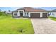 Beautiful single-story home with a brown roof, three-car garage, and paved driveway at 15 Tournament Rd, Rotonda West, FL 33947