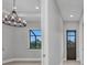 Hallway with a modern chandelier, an outdoor view, and a neutral color scheme at 15 Tournament Rd, Rotonda West, FL 33947