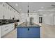 Contemporary kitchen with a large dark island, white cabinetry, and high-end stainless appliances at 15 Tournament Rd, Rotonda West, FL 33947