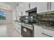 Modern kitchen with stainless steel oven, black hardware, and granite countertops at 15 Tournament Rd, Rotonda West, FL 33947