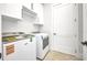 Bright laundry room with new washer and dryer and plenty of storage at 15 Tournament Rd, Rotonda West, FL 33947