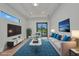 Bright living room with modern decor, a large window, and access to the outdoor area at 15 Tournament Rd, Rotonda West, FL 33947