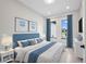 Comfortable bedroom with a large bed, stylish blue decor, and lots of natural light at 15 Tournament Rd, Rotonda West, FL 33947