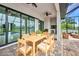 Outdoor patio area featuring a dining table, ceiling fans, access to a pool, and outdoor kitchen at 15 Tournament Rd, Rotonda West, FL 33947