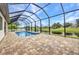 A beautiful screened in pool overlooks a pond with blue skies above at 15 Tournament Rd, Rotonda West, FL 33947