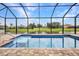 A beautiful screened in pool with a fountain overlooks a scenic pond at 15 Tournament Rd, Rotonda West, FL 33947