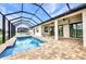 A stunning screened-in pool area with brick pavers and a lake view at 15 Tournament Rd, Rotonda West, FL 33947