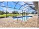 A beautiful screened in pool with a fountain overlooks a scenic pond at 15 Tournament Rd, Rotonda West, FL 33947