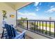 Balcony with blue Adirondack chairs and view of the water and clear sky at 1500 Park Beach Cir # 2F, Punta Gorda, FL 33950