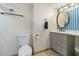Well-lit bathroom features modern vanity with an oval mirror, toilet, and neutral finishes at 1500 Park Beach Cir # 2F, Punta Gorda, FL 33950