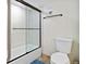 Bathroom features a toilet and a bathtub with glass doors and neutral finishes at 1500 Park Beach Cir # 2F, Punta Gorda, FL 33950