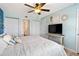 Bright bedroom with light blue walls, a ceiling fan, and a door leading to the bathroom at 1500 Park Beach Cir # 2F, Punta Gorda, FL 33950