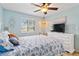 Comfortable bedroom with blue accents, a white dresser with TV, and warm natural lighting at 1500 Park Beach Cir # 2F, Punta Gorda, FL 33950